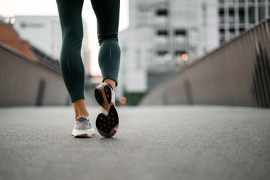 Spor ayakkabılı sporcuların arka plandaki yakın plan görüntülerinden birini parmak ucunda bulanık bir zemine yerleştirdi.