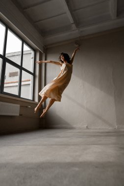 Kırılgan, narin kadın dansçı, sanki havada uçan bir kuş gibi zıplıyormuş gibi zıplıyor.