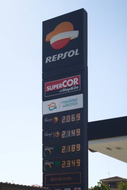 Repsol şirketinin benzin istasyonundaki arabaların en yaygın fosil yakıtları için bir fiyat panelinin resmi