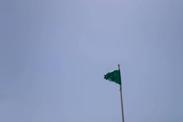 Közelkép Egy Zöld Zászlót Strandon Sziluett Ellen Kék Nyári Szimbolizálja — Stock Fotó