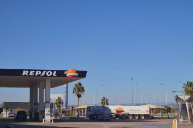Yakıt tedarikçisi Repsol adlı çok uluslu şirkete ait bir benzin istasyonunun, park halindeki arabaların olduğu bir fotoğrafı. Kopyalama alanı olan resim.