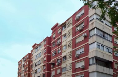Düşük gelirli yerleşim yerlerindeki bazı eski apartman bloklarının görüntüsü. Pencerelerinde klima ve güneş gözlüğü var.