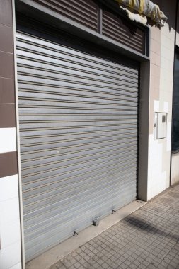 Farklı krizlerin (finansal, ekonomik, sağlık, sosyal, sosyal) etkileri nedeniyle kapatılan ve panjurları kapatan bir işletmenin dış cephesi)