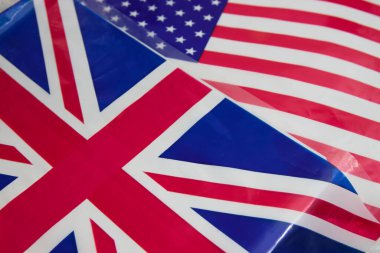 Amerika ve İngiltere gibi iki kardeş ülkenin plastik bayraklarının düzlüğü bir masada, kavramsal arka planda.