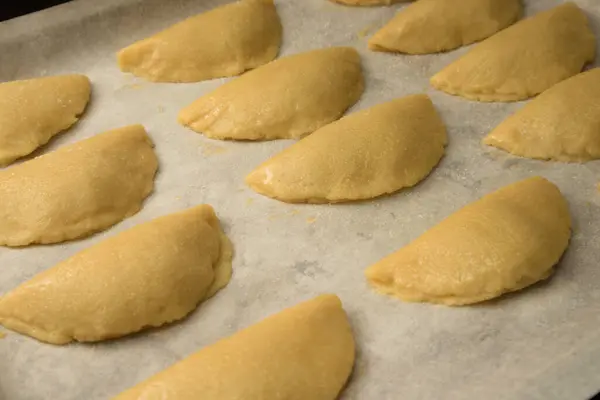 A baking tray with uncooked sweet potato pastries (pastissets) waiting to be baked. Typical Christmas sweet in Spain