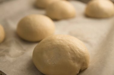 Arkadan aydınlatılmış birkaç top ev yapımı hamburgerle pişirme tepsisi.