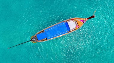 Tayland 'daki Phi phi adasında uzun kuyruklu teknede dinlenen bir turist..