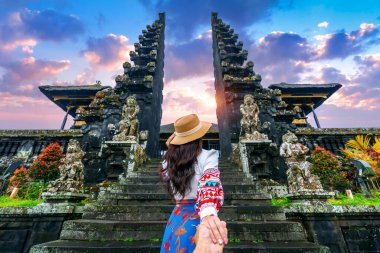 Kadın turistler adamın elini tutarak ve Bali, Endonezya Besakih tapınağına onu lider.
