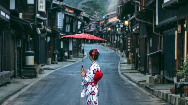 Japonya 'nın Nagano kentindeki Narai Juku' da geleneksel Japon kimonosu giyen Asyalı kadın. Çeviri: Narai Juku Köyü