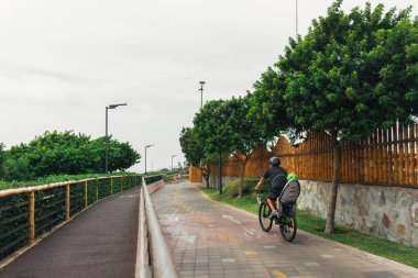 Miraflores bölgesinde bisiklet süren tanınmayan yetişkin bir adam ve çocuk, Lima Peru