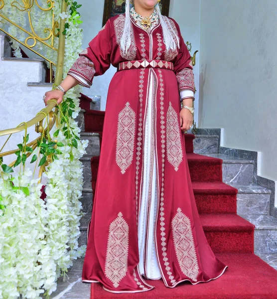 一名身穿红色卡夫坦的摩洛哥妇女站在楼梯上 — 图库照片