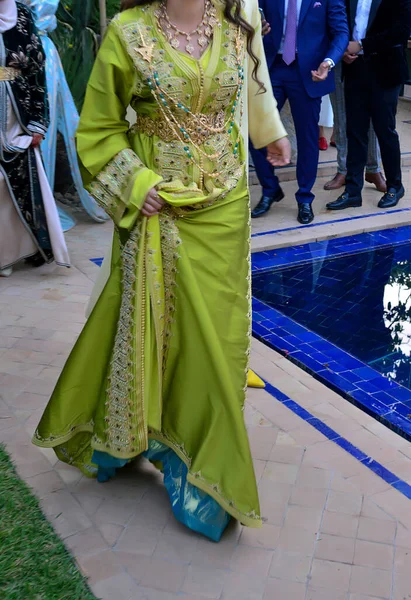 一名身穿绿色摩洛哥咖啡色衣服的摩洛哥妇女走在游泳池前 — 图库照片