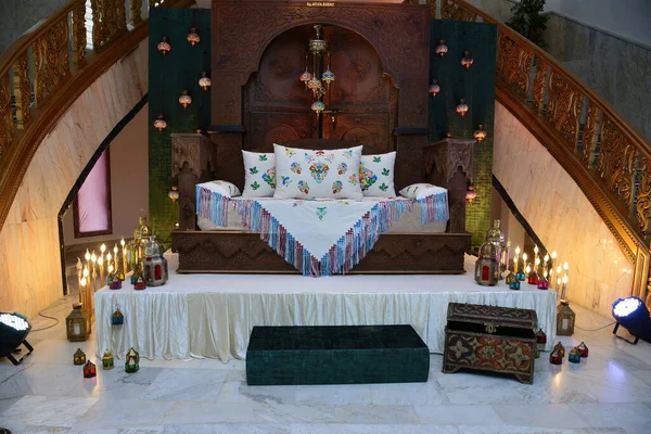 stock image An elegantly staged traditional morocco style wedding with large sofa for the wedding couple to sit and receive blessings from the guests, surrounded by beautiful floral decor and candle light stands