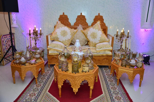 美しい花の装飾とキャンドルライトスタンドに囲まれ ゲストから祝福を受けるために結婚式のカップルのための大きなソファとエレガントに上演された伝統的なモロッコスタイルの結婚式 — ストック写真