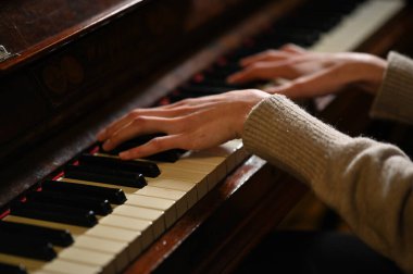Kadın elleri piyano çalarken yakın çekim görüntüsü 