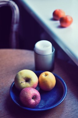 Tahta bir masada taze elma ve mum.