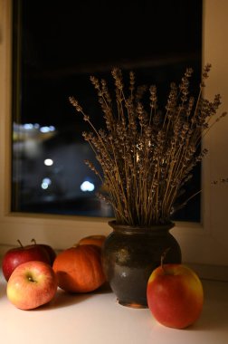 Pencere kenarındaki vazoda elmalar ve lavantalar