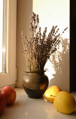 Pencere kenarındaki vazoda elmalar ve lavantalar
