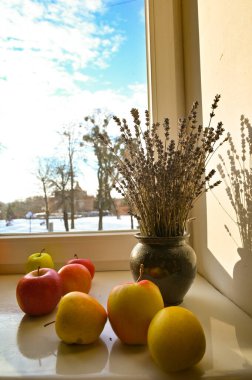 Pencere kenarındaki vazoda elmalar ve lavantalar