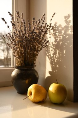 Pencere kenarındaki vazoda elmalar ve lavantalar