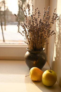 Pencere kenarındaki vazoda elmalar ve lavantalar
