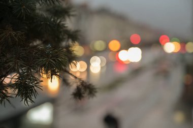Pencere kenarında noel ağacı ve şehir ışıkları arka planda bulanık