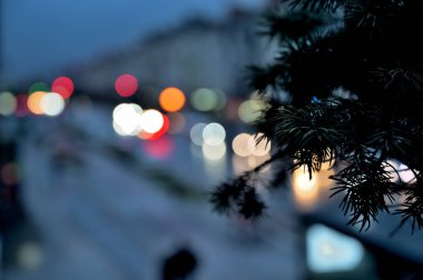 Pencere kenarında noel ağacı ve şehir ışıkları arka planda bulanık