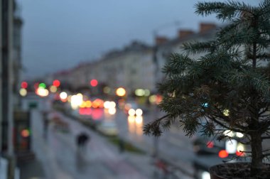Pencere kenarında noel ağacı ve şehir ışıkları arka planda bulanık