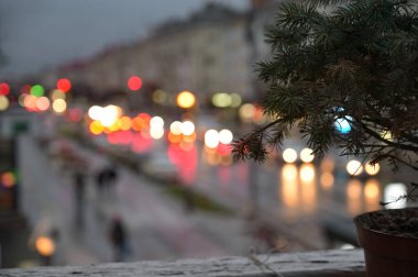 Pencere kenarında noel ağacı ve şehir ışıkları arka planda bulanık