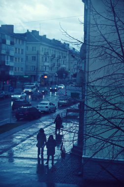 İnsanlar eski bir şehirde sokakta yürüyorlar. 