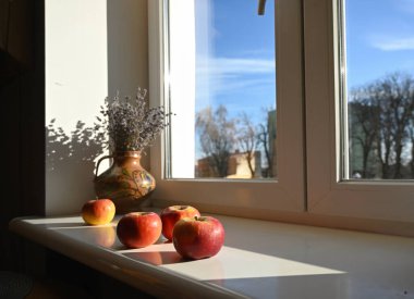 Pencere kenarındaki vazoda elmalar ve lavantalar