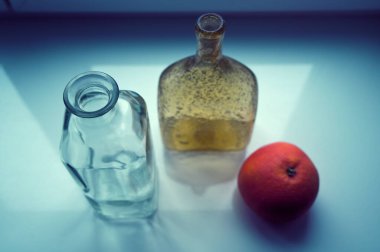 Taze turuncu ve boş şişeler masada. 