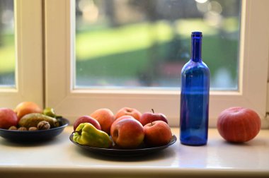 Pencere kenarında bir bardak elma suyu, yakın plan.