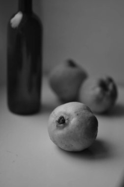 Beyaz bir yüzeydeki olgunlaşmamış incirin dikey görüntüsü.