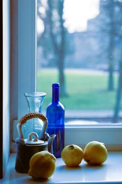 Bir armut, bir sürahi, bir limon ve bir masanın üzerindeki bir pencere.