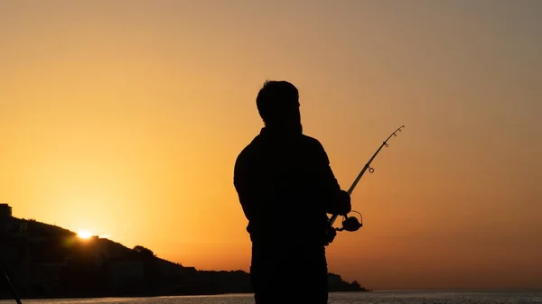 Sylwetka Stojącego Mężczyzny Łowiącego Ryby Zachodzie Słońca Mężczyzna Trzymający Wędkę — Zdjęcie stockowe