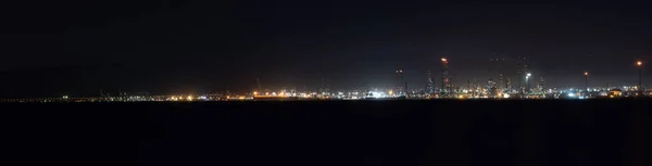 Panoramic view of industrial area at night in Gulf of Izmit Turkey. Factory lights at night
