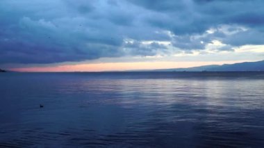 Deniz yüzeyi. Sakin, sakin bir deniz görüntüsü. Kasvetli havada deniz yüzeyinde yansımalar