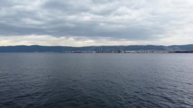Aerial view of industrial area by the sea. Oil refinery plant. Petrochemical factory and merchant ships in Gulf of Kocaeli Izmit Turkey. Aerial footage