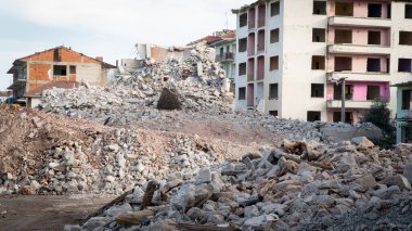 Earthquake damage in a city. Destroyed buildings after an earthquake. Collapsed buildings. Ruined city because of war. Airstrike damages a city. Urban transformation concept. Selective focus included