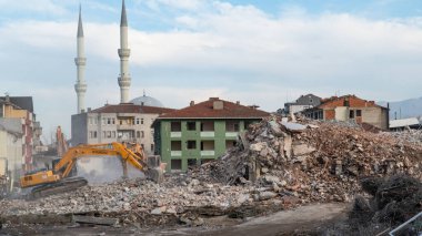 Urban transformation, the process of redevelopment and revitalization of urban areas. Excavators in construction site demolishing old buildings in Golcuk Kocaeli Turkey. Selective focus included