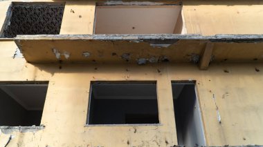 War damage in a city. Buildings damaged by an enemy aircraft missiles. Ruined city. Attack on civilian settlements. War crime. Selective focus included.
