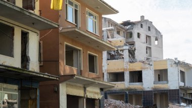 Urban transformation, the process of redevelopment and revitalization of urban areas. Excavators in construction site demolishing old buildings in Golcuk Kocaeli Turkey. Selective focus included.