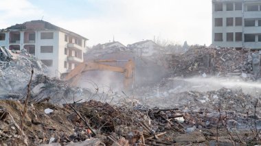 Urban transformation, the process of redevelopment and revitalization of urban areas. Excavators in construction site demolishing old buildings in Golcuk Kocaeli Turkey. Selective focus included.