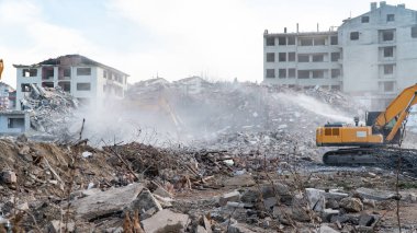Urban transformation, the process of redevelopment and revitalization of urban areas. Excavators in construction site demolishing old buildings in Golcuk Kocaeli Turkey. Selective focus included.