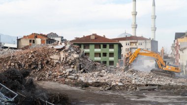 Urban transformation, the process of redevelopment and revitalization of urban areas. Excavators in construction site demolishing old buildings in Golcuk Kocaeli Turkey. Selective focus included