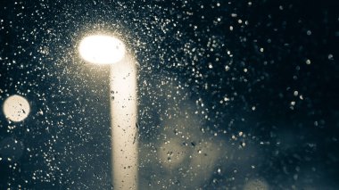 Raindrops on a window. Rain at night background with bokeh street light