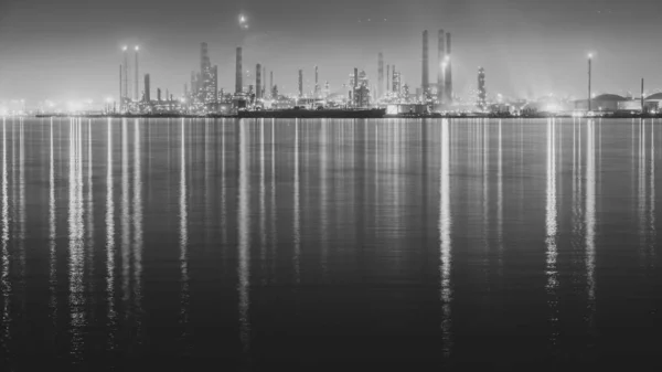 石油精炼厂晚上 炼油厂的灯反射到海上 夜景长期曝光摄影 包括有选择的重点 — 图库照片