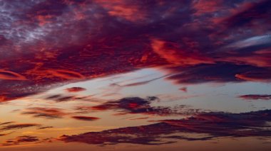 Sunset sky. Cirrocumulus and cirrostratus clouds during sunset. Beautiful dramatic sunset sky background. Selective focus included. Noisy photo