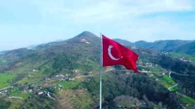 Dağın tepesinde Türk bayrağı var. Tepesinde güzel manzaralı Türk bayrağı var. Türk bayramları. 23 Nisan, 19 Mayıs, 30 Agustos, 29 Ekim konsepti. İHA görüntüsü. Havadan sinematik çekim.